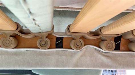 Nahaufnahme des höhenverstellbaren Lattenrosts und der Retro-Räder des Laufstalls