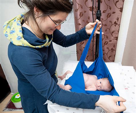 Hebamme bei der Betreuung einer frischgebackenen Mutter und ihres Babys