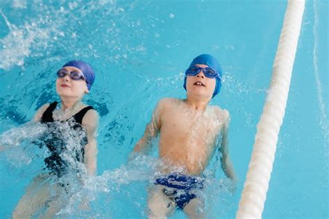 Eine Gruppe von Kindern lernt spielerisch schwimmen.