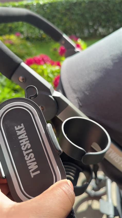 Nahaufnahme des Cybex Becherhalters, der am Griff des Kinderwagens befestigt ist und eine Flasche hält