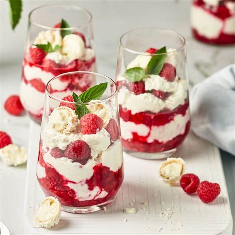 Nahaufnahme eines Himbeertraum-Desserts im Glas mit sichtbaren Schichten und Dekoration