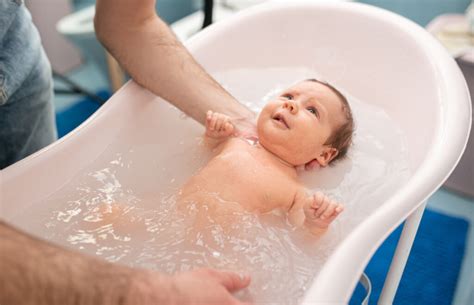 Illustration einer Familie, die ein Baby in einer Babywanne badet.