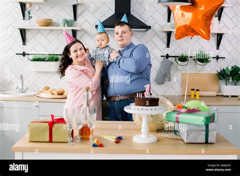 Familie feiert den ersten Geburtstag mit Kuchen und Dekoration