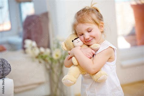 Kind kuschelt liebevoll mit einem weichen Teddybären